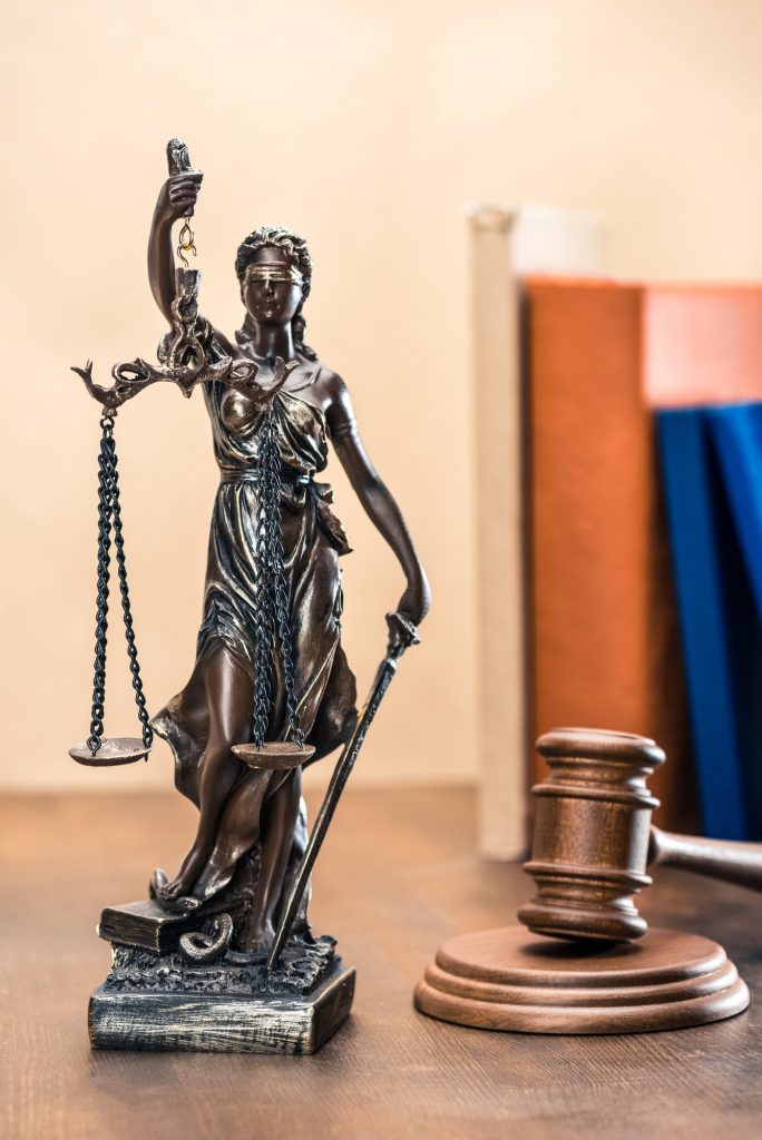 Close-up view of statue of lady justice and mallet, Law concept